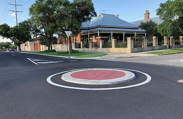 The intersection of a suburban street showing a mini roundabout