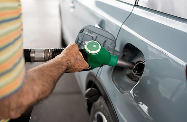 A close up of a man filling this car with petrol