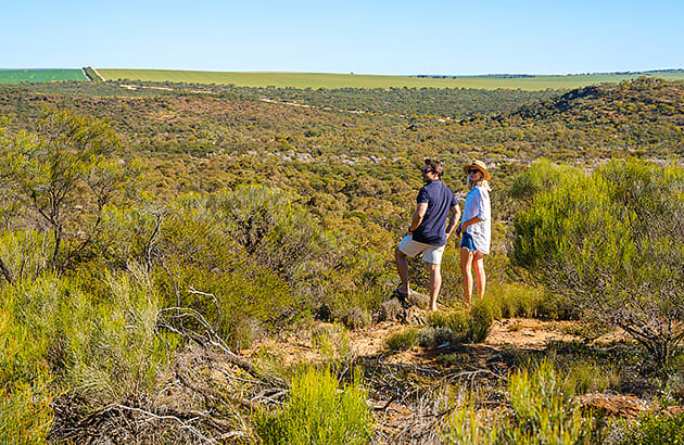 A man and woman standing on a high point on Depot Hill, Mingenew