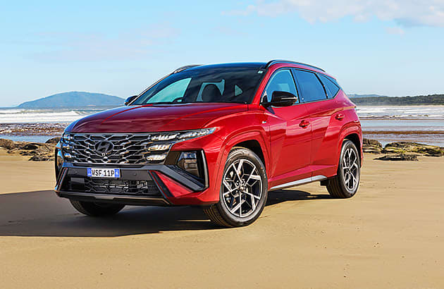 A red Hyundai Tuscon parked on a beach