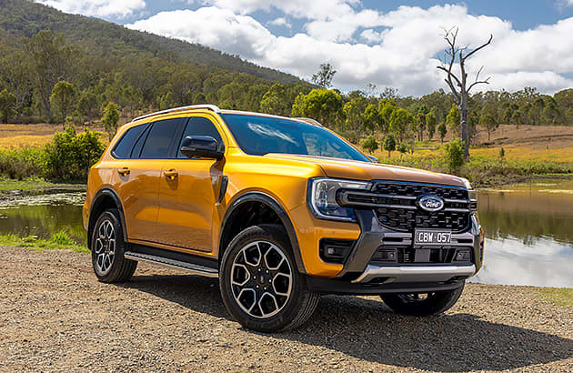 An orange Ford Everest parked near a farm dam