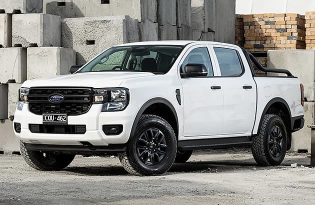 A white Ford Ranger parked near large concrete blocks