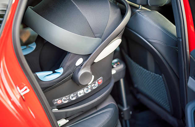 A baby capsule installed in the rear seat of a car