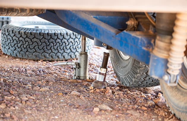 Bottle jack being used on a caravan to help change a tyre