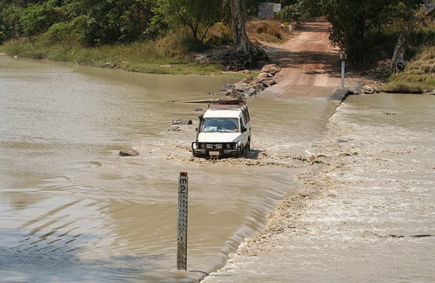 A four-wheel drive crossing a flooded country road