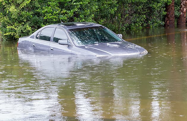 A car in water up to the bottom of the windows