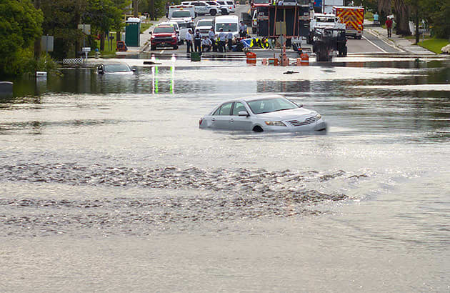 Two cars sunk in flood waters on a road