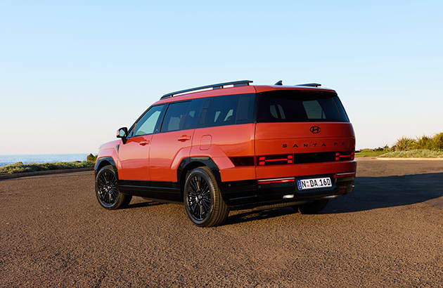 An orange 2024 Hyundai Santa Fe in a carpark