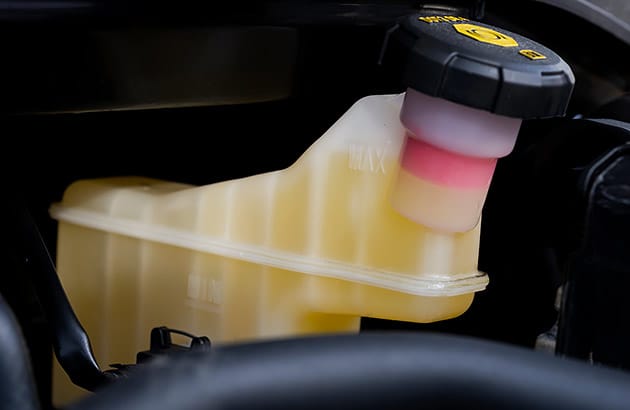 A brake fluid reservoir showing the high and low fill levels