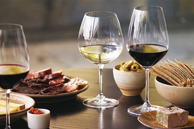 A wine and cheese board in the dining cart of a train