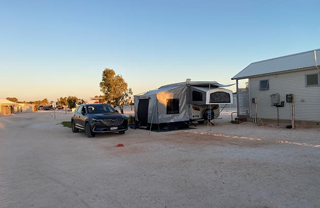 A car parked in a caravan park next to a caravan bay