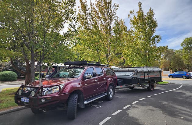 A red 4WD with a caravan hitched to it