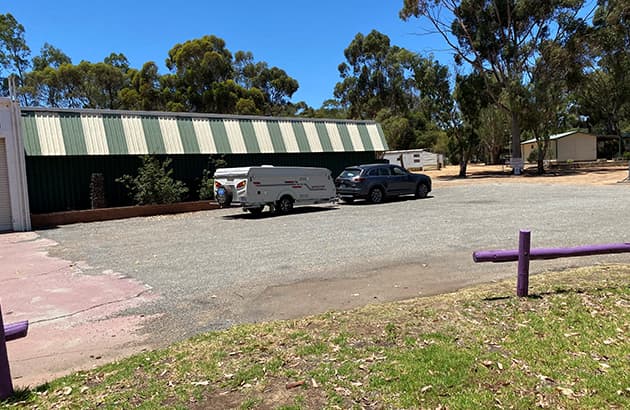 A car with a caravan pulled over at a rest stop