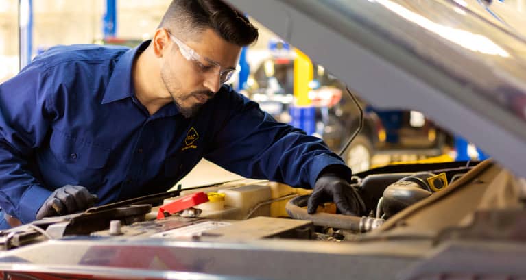 A mechanic looking at a dipstick