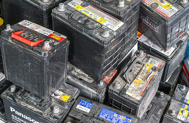 A large pile of old car batteries