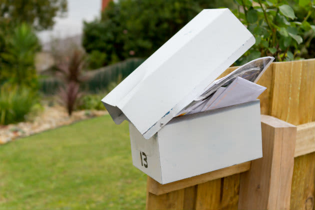An overflowing white mailbox