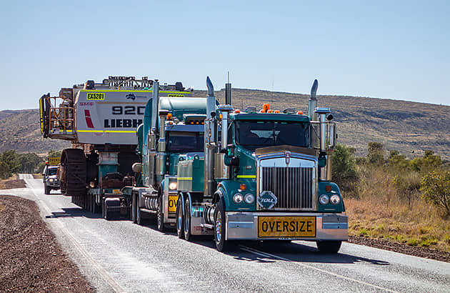 A truck carrying an oversize load on a WA country road