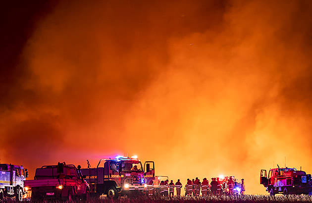 Fire trucks with a bushfire burning in the background