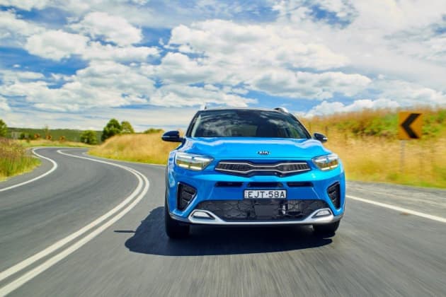 Blue Kia Stonic driving down country road