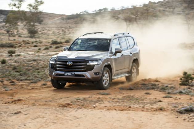 Silver Toyota Landcruiser 300 Series driving on dirt path