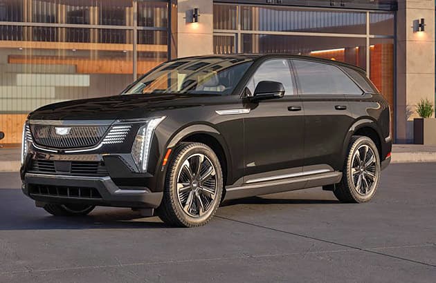 A black Cadillac Escalade parked in front of modern apartments