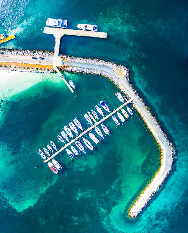 An arial view of two rows of sailing boats moored within the  Esperance Bay Marina