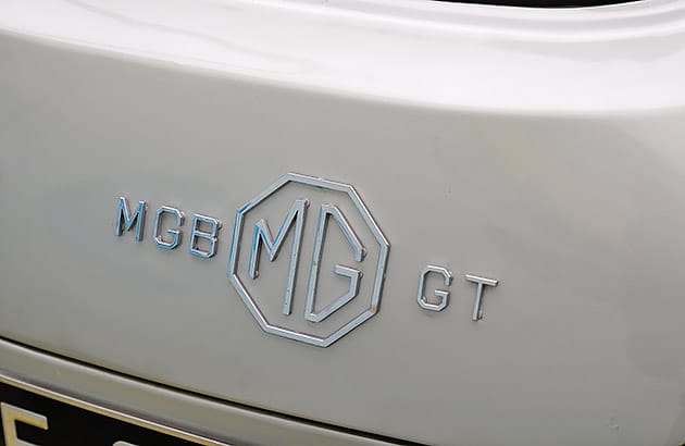A close up an MGB logo on a cream coloured MGB car