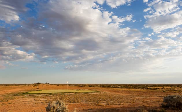 A cloudy sky looks down on the dusty barren land of the Nullarbor Links Golf Course