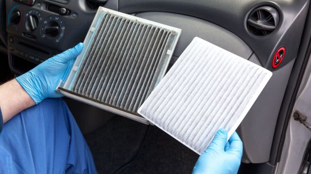 Hands holding a dirty and a clean car air filter