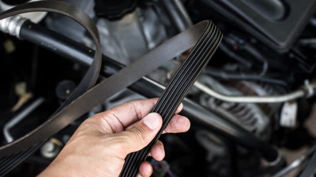 hand holding old timing belt