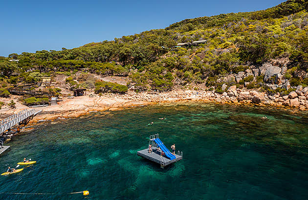A pontoon with a slide in the water near the beach at Woody Island