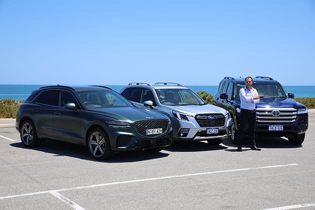 RAC's Alex Forest is standing in front of a Genesis, Subaru and Toyota vehicles.