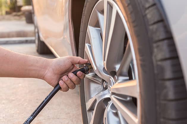 Inflating car tyre with pressure hose