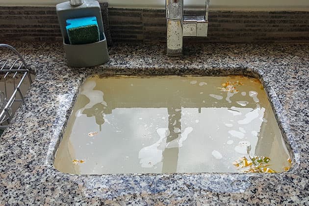 Kitchen sink full of blocked water