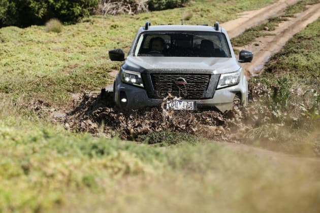 Grey Navara Ute driving into puddle