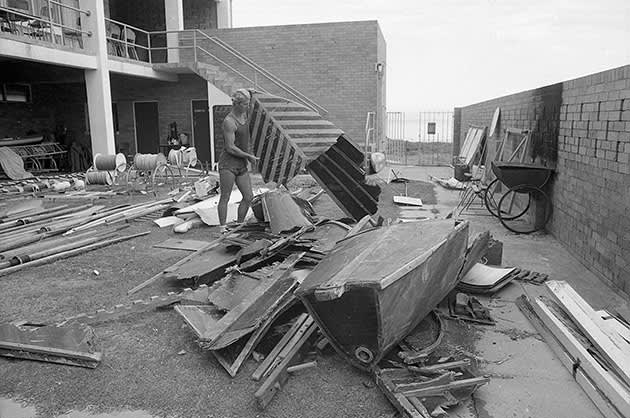 A person is inspecting the extensive damage to the  Cottesloe Surf Lifesaving Club