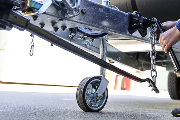 A person is adjusting the weight distribution hitch on their caravan.