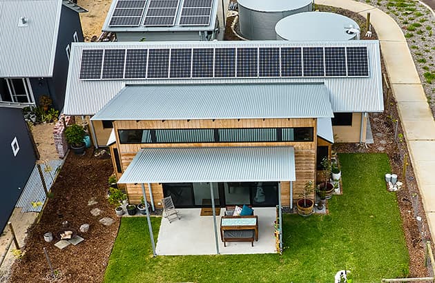 Aerial image of a home showing solar panels and rain water tanks