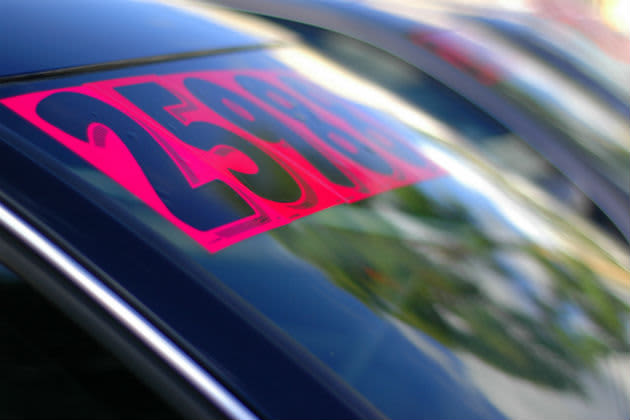 'For sale' sign on car at dealership