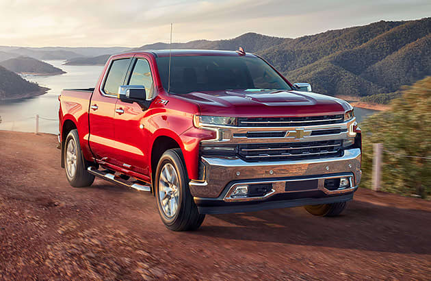 A red Chevrolet Silverado parked on a red gravel hillside