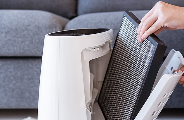 A person changing an air purifier filter
