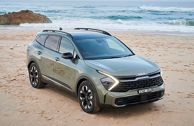 A green Kia Sportage parked near the beach