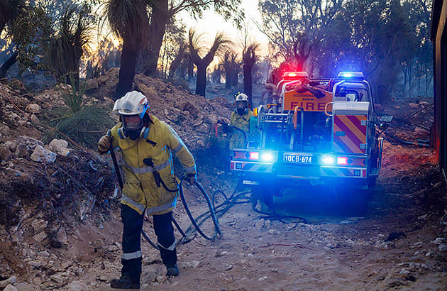 Fire fighters near a truck at the scene of a bush fire