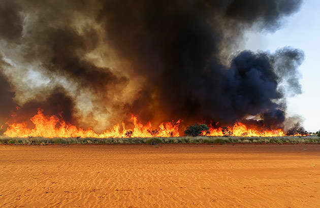 A line of smoke and flames from a bushfire in a remote area