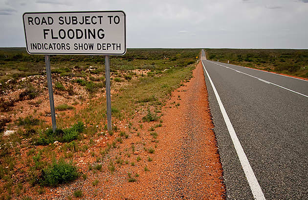 A flood warning sign on a remote road