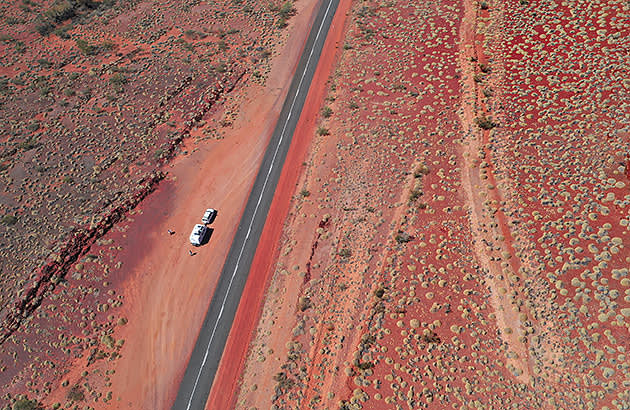 A car with a caravan pulled over on a remote country road