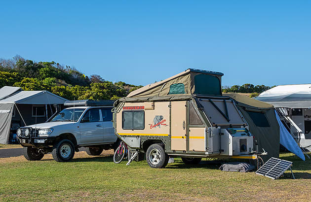 Caravans and cars on a grassed area in a caravan park