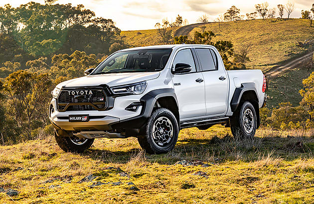 A white Toyota HiLux in a farmland setting