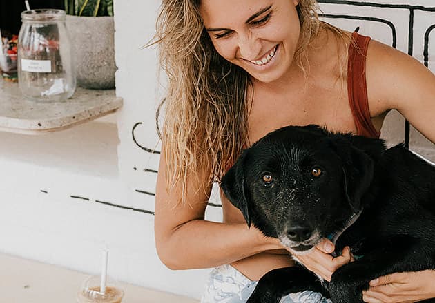 A black Labrador sitting on a woman's lap