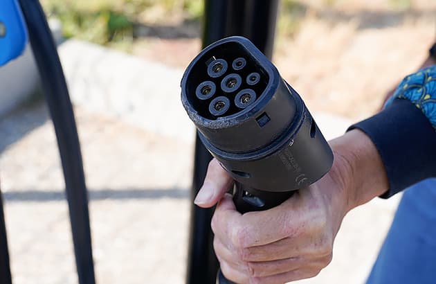 Someone holding a type 2 electric car charging plug